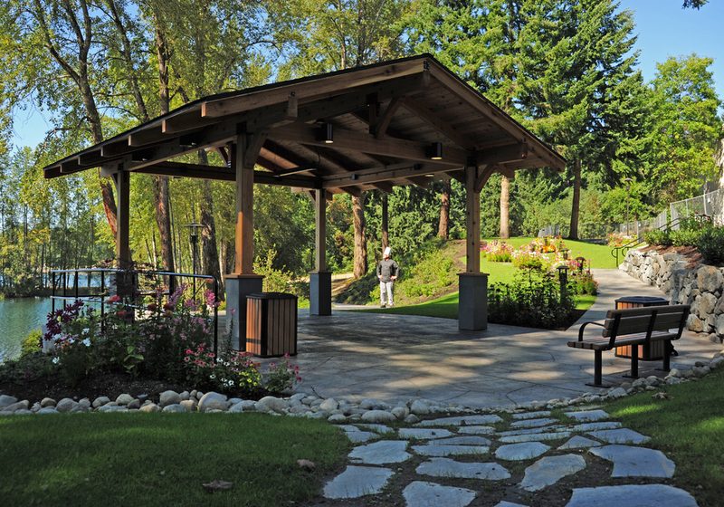 A timber garden pavilion beside a curving stone stepping path and planted borders
